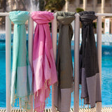 ein Hamamtuch Strandtuch in Aquablau, Rosa, Braun und Grau, das am Pool hängt