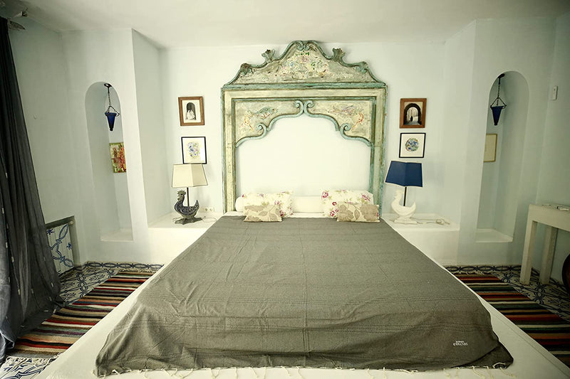 ein khakifarbener Bettüberwurf auf einem Arabeskenbett