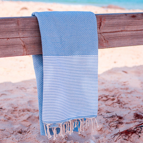  blaues Strandtuch am Strand aufgehängt