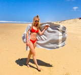 Frau im roten Bikini am Strand mit blauem Hamamtuch fouta