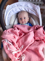 Baby in rosa Strandtuch bedeckt
