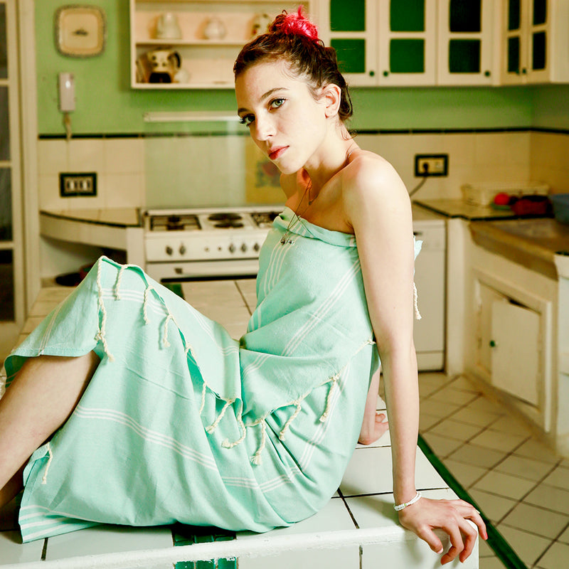 Frau in der Küche mit einem aquablauen Strandtuch