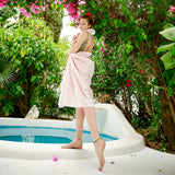Mädchen in rosa Strandtuch Saunatuch faulenzen am Pool im Garten