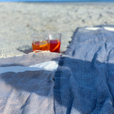 ein hellgraues Strandtuch und ein dunkelgraues Strandtuch auf dem Sand
