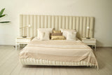 ein beiges und weißes Bettüberwurf auf einem Kingsize-Bett
