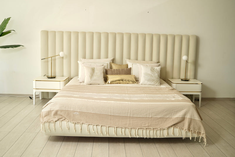 ein großes Bett, das mit einer hellgrauen Bettüberwurf bedeckt ist