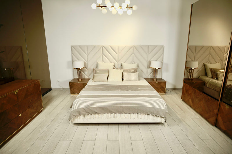 ein großes Bett mit einer hellgrauen Bettüberwurf Decke