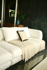 ein beiger und weißer Überwurf Sofaüberwurf auf einem weißen Sofa im Wohnzimmer